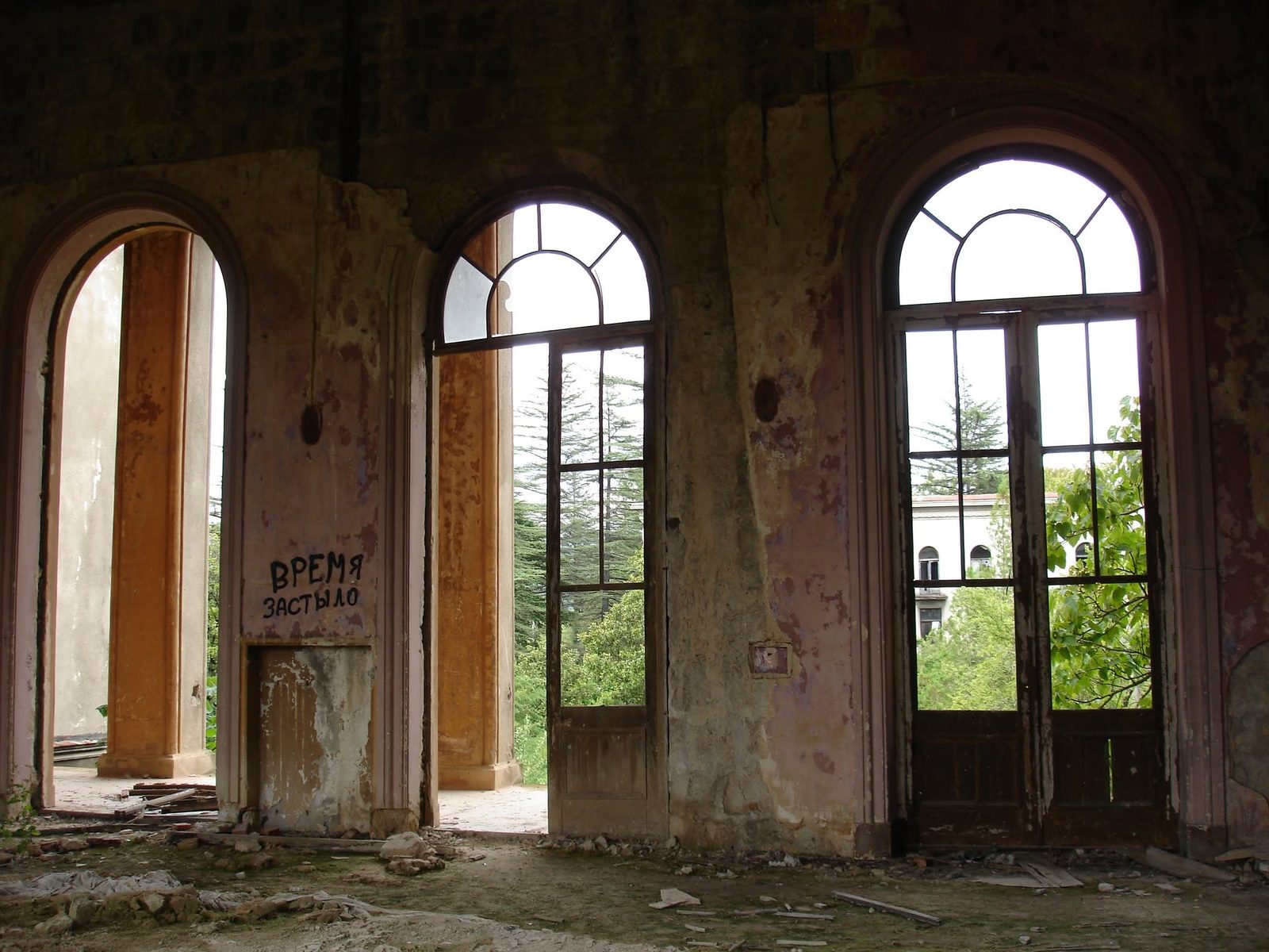 Ein Saal mit Bogenfenstern. Jemand hat „Die Zeit ist stehen geblieben“ an die Wand geschrieben.