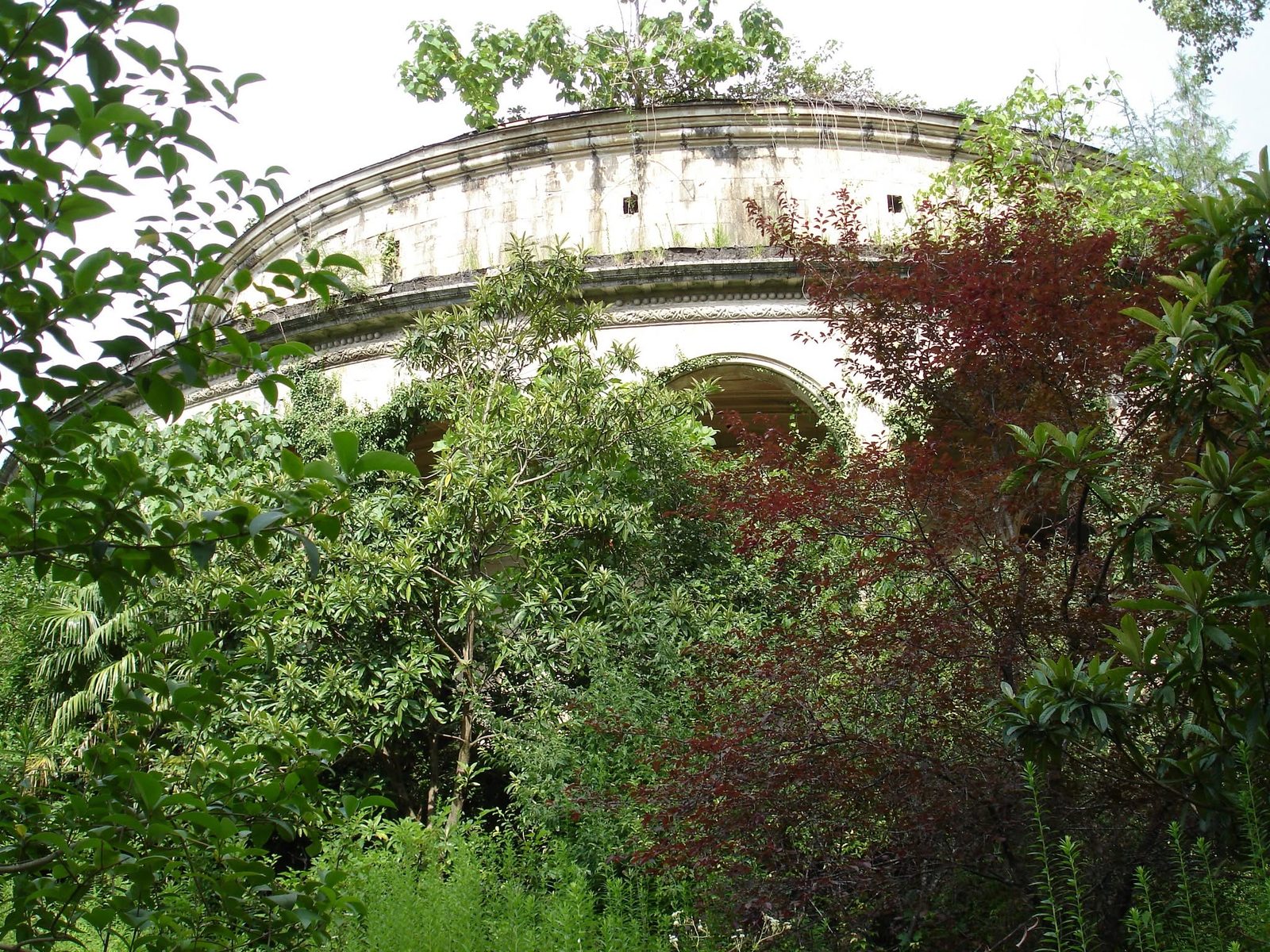 Eine Rotunde, fast verdeckt von Pflanzen.