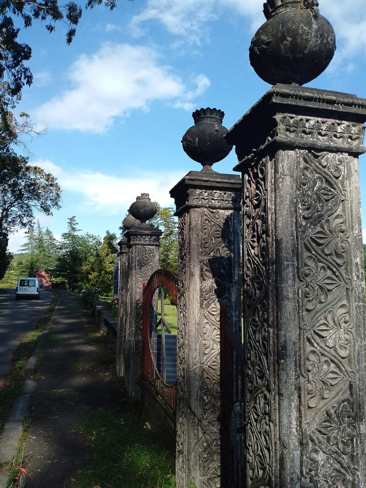 Geschnitzte Steinpfeiler am Straßenrand.